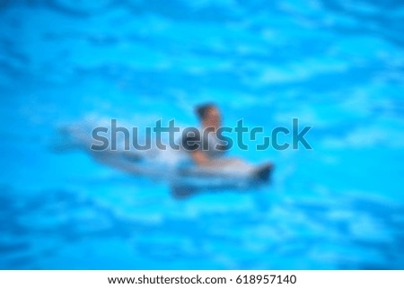 Picture blurred for background abstract and can be illustration Blurred Girl playing with on a dolphin