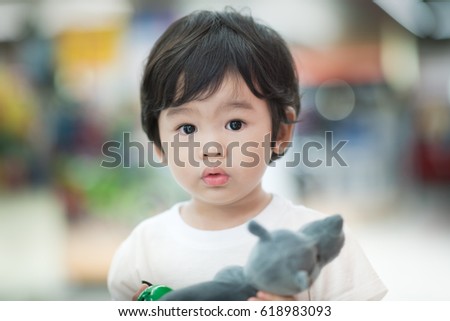 A little boy happy and excited in toys shop, blurry colorful background