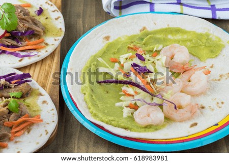 Close up of plate with shrimp taco with guacamole.