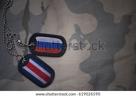 army blank, dog tag with flag of russia and costa rica on the khaki texture background. military concept