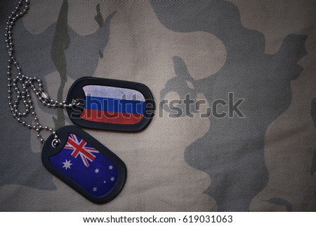 army blank, dog tag with flag of russia and australia on the khaki texture background. military concept