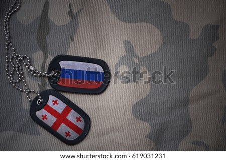 army blank, dog tag with flag of russia and georgia on the khaki texture background. military concept