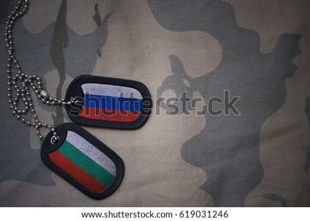 army blank, dog tag with flag of russia and bulgaria on the khaki texture background. military concept