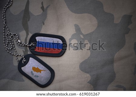 army blank, dog tag with flag of russia and cyprus on the khaki texture background. military concept