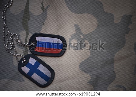 army blank, dog tag with flag of russia and finland on the khaki texture background. military concept