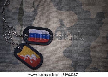army blank, dog tag with flag of russia and bhutan on the khaki texture background. military concept