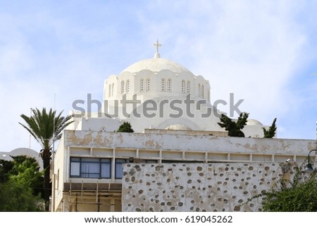 A large dome of an Orthodox church with a cross at the top, Crete, Greece