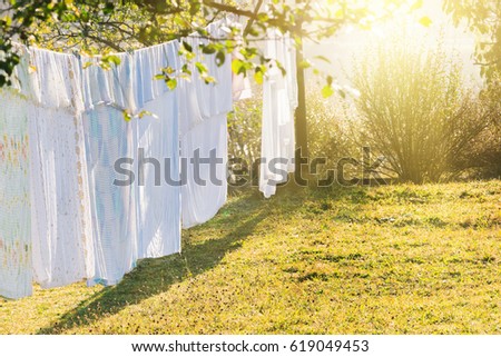 Laundry drying on a rope in the yard in the sunlight Royalty-Free Stock Photo #619049453