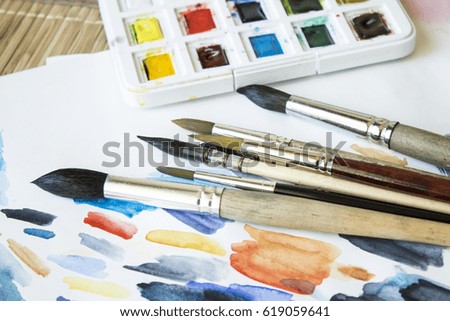 Closeup photo of brushes and watercolor paints.