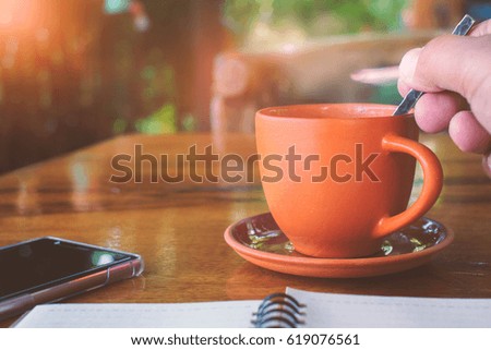 Hot coffee in the morning with smartphone and notebook.Vintage style