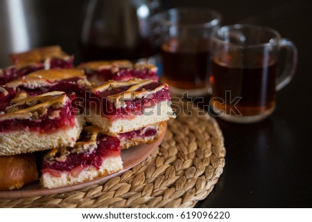 Pieces of a berry pie on a board with tea