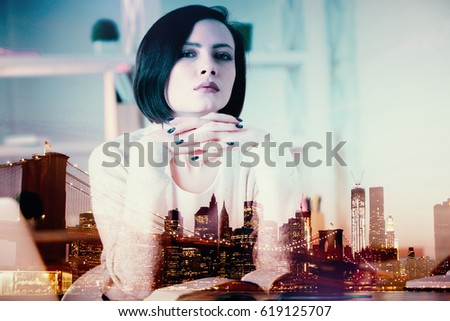 Thinking european woman at workplace with open book on abstract city background. Double exposure