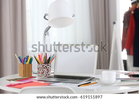 Fashion designer workplace with laptop on table