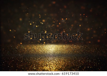 glitter vintage lights background. gold and black. de-focused.