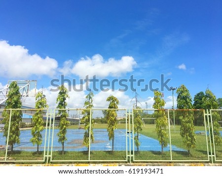 Beatiful blue sky on the basketball sport field with tree fence background in summer in thailand