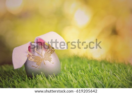 Happy easter day on april, Easter eggs and cute bunny in green grass. Selective focus and toned image. Free space for text. Vintage effect.