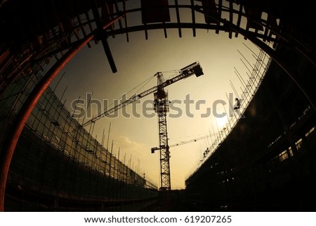  Construction workers working on scaffolding.The effect of backlight under the sunset silhouette.Yellow warm background photos.