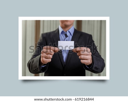 Businessman holding visit card. Man showing blank business card. Person in black suit. Mock up design. Photo frame design with shadow.