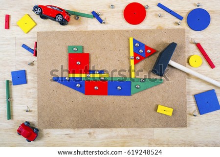 Blocks, hammer and nails on a table colorful background . Top view.
