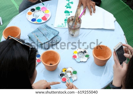 group of friend paint a picture on pot.