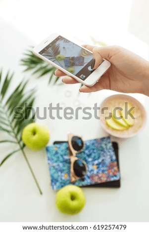 Woman hand taking summer pictures while eataing nutritious breakfast. Photography concept.
