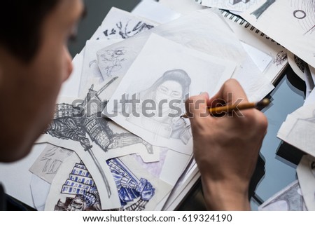 tattoo artist draws sketches for a tattoo. the guy draws beautiful pictures