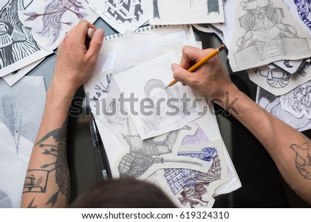 tattoo artist draws sketches for a tattoo. the guy draws beautiful pictures