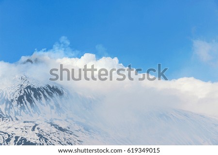 smoke around mount etna after eruption in winter