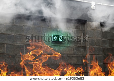 Emergency Fire Exit on the stone wall with fire and smoke