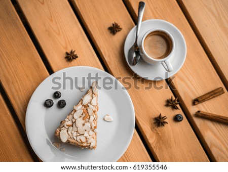 Layer cake with fruit and cappuccino coffee on wooden table