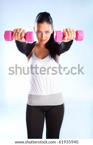 Young woman hang up hands weights ,studio shot
