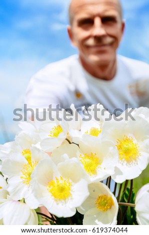 Romantic man with a bouquet of white flowers on a summer day