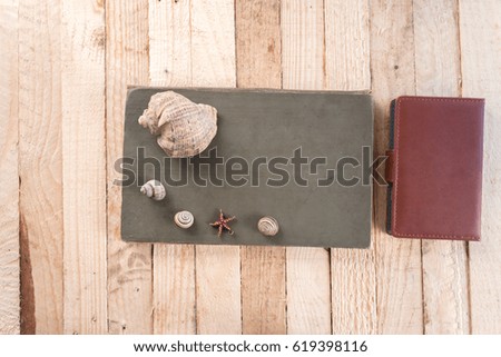 Notebook on a wooden background with seashells
