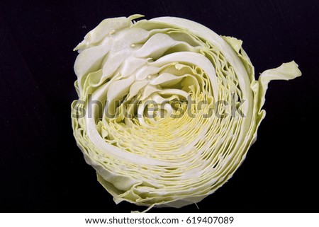Closeup photo of half sliced fresh ripe raw cabbage with wavy leaves, horizontal picture