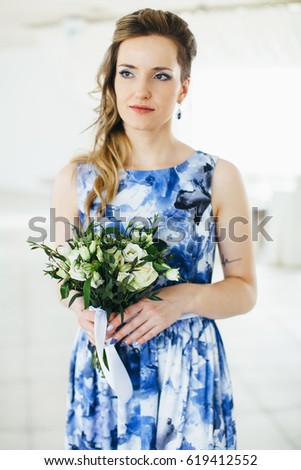 Portrait of bride with bouquet. Wedding in interior