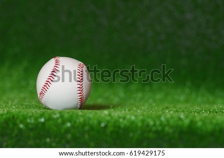 a baseball in a grass background