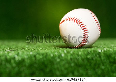 a baseball in a grass background