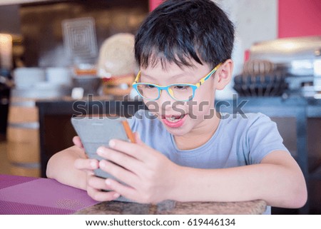 Young asian boy playing games on smart phone