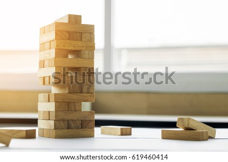 the blocks wood tower game with architectural engineer plans or blue prints compasses ,pencils and ruler on wooden table, plan and building concept. Royalty-Free Stock Photo #619460414