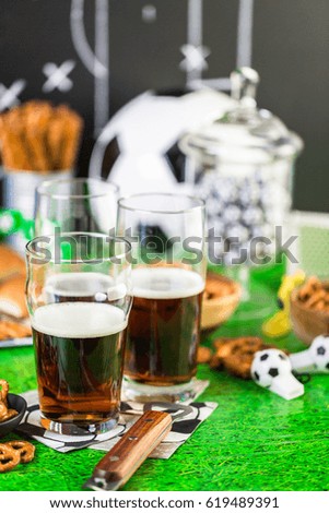 Salty snacks and beer on the table for soccer party.