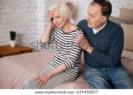 Man giving solace to his senior wife with headache Royalty-Free Stock Photo #619490057