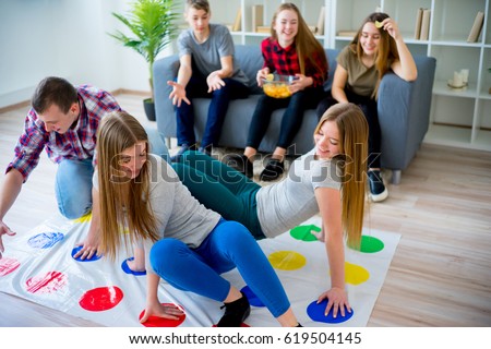 Friends playing twister Royalty-Free Stock Photo #619504145