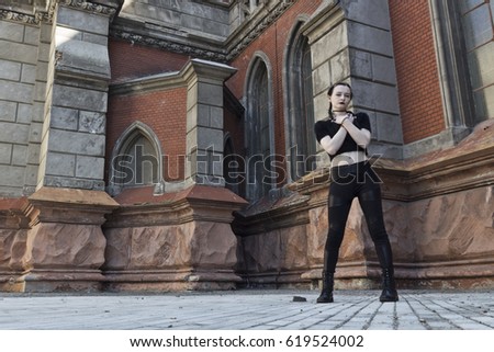Gothic girl, against the background of old gothic architecture