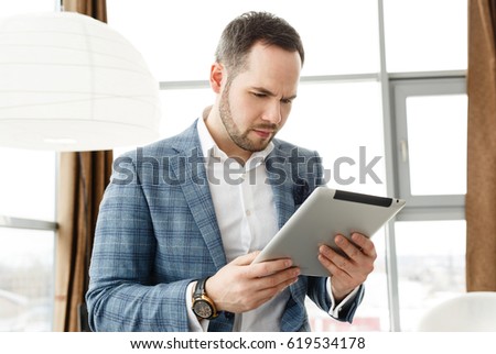businessman with tablet in hand in the blue jacket in the office