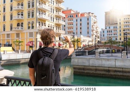 Male tourist is taking picture in the Qanat Quartier in Doha, Qatar