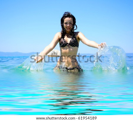 Young beautiful tanned woman in bikini in the sea