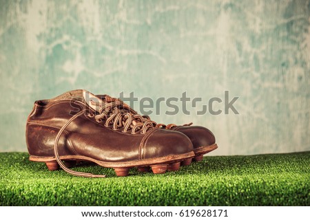Retro outdated soccer or football spike boots. Vintage old style filtered photo