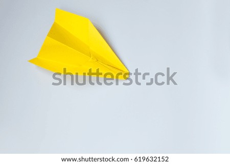 holidays, tradition, style and minimalism concept - Yellow origami plane on a white background.