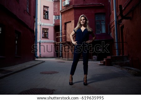 Beautiful blonde young woman walking on the street. Flare for text and design. Lifestyle girl in the city
