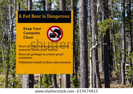 Informative sign warning of the dangers of bears and unclean campsites, and penalty for disobeying .